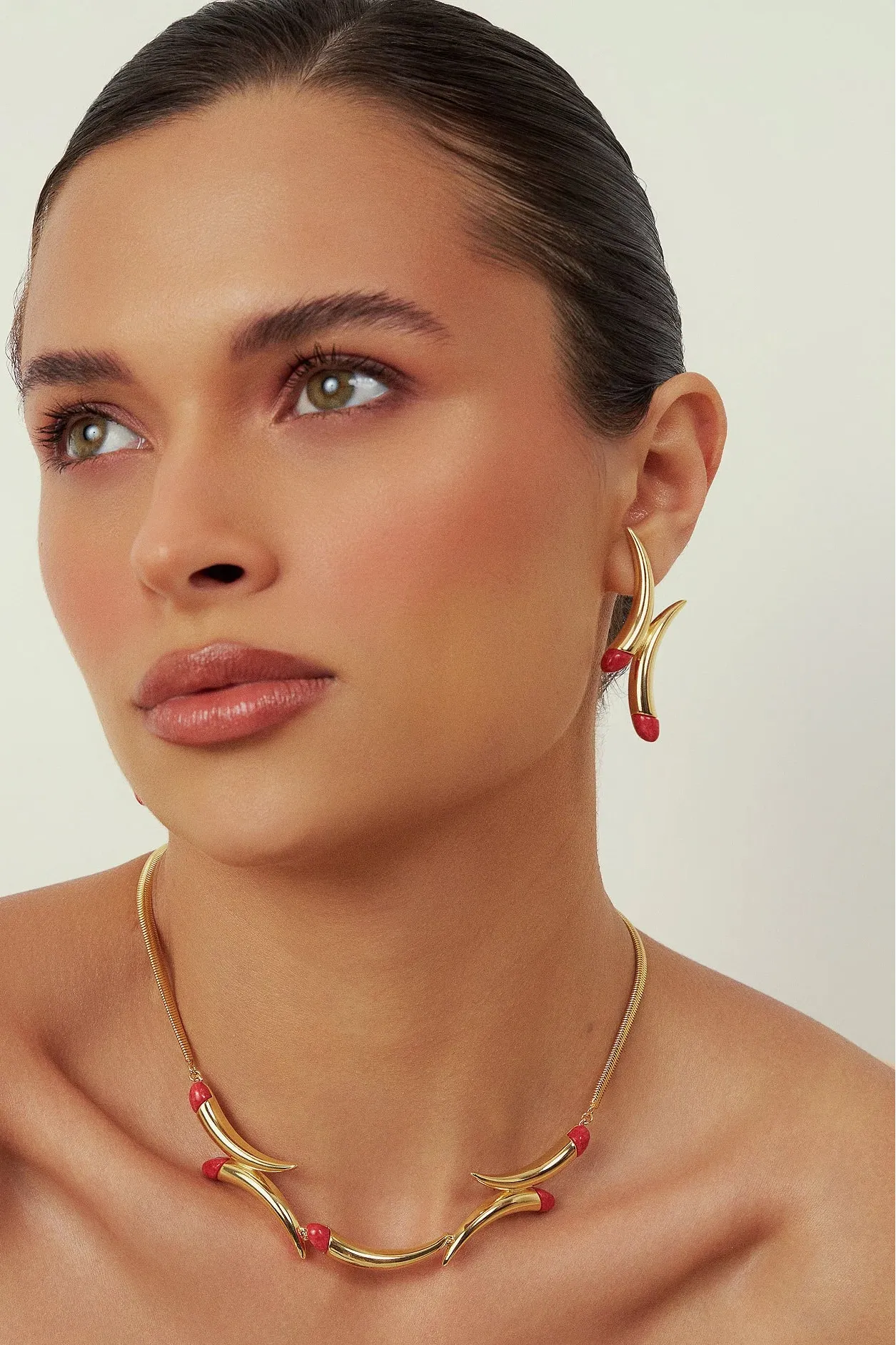 Use o Brinco Caminhos com Feldspato Vermelho em Banho de Ouro 18K para adicionar paixão e energia ao seu visual, unindo estilo e simbologia.