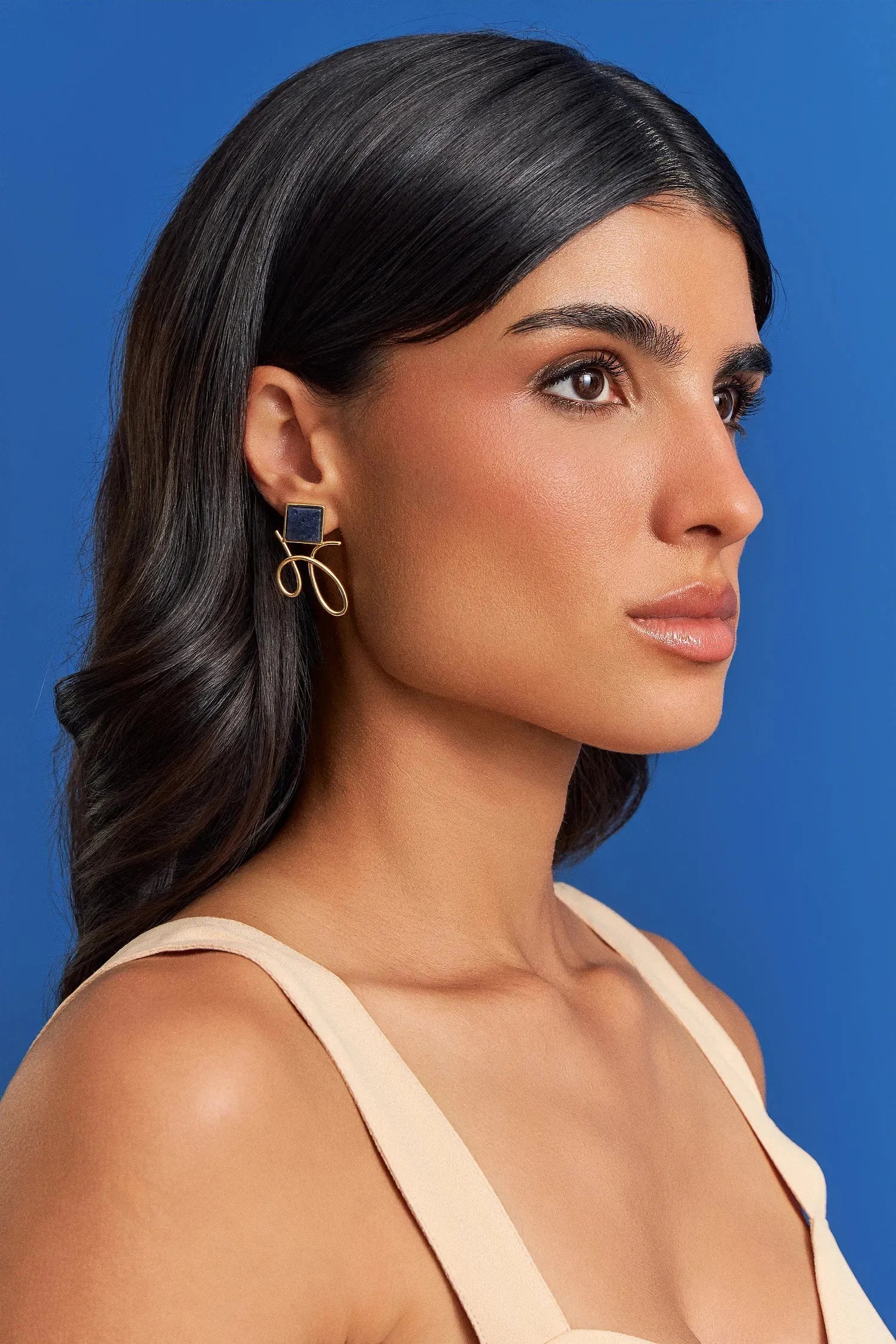 O Brinco Esboço com Sodalita em Banho de Ouro 18K traduz o instante em que o traço encontra a forma. Este brinco pequeno e delicado une a pedra quadrada, que atua como ponto de luz, a um toque sutil de traço. A Sodalita simboliza clareza e intuição. Com sua geometria precisa e o contraste sutil das linhas em metal, esta peça é perfeita para quem busca expressar sofisticação e leveza, elevando o visual com um toque contemporâneo.