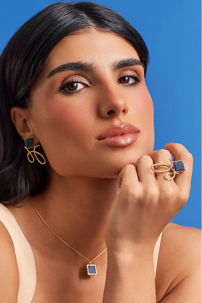 O Brinco Esboço com Sodalita em Banho de Ouro 18K traduz o instante em que o traço encontra a forma. Este brinco pequeno e delicado une a pedra quadrada, que atua como ponto de luz, a um toque sutil de traço. A Sodalita simboliza clareza e intuição. Com sua geometria precisa e o contraste sutil das linhas em metal, esta peça é perfeita para quem busca expressar sofisticação e leveza, elevando o visual com um toque contemporâneo.