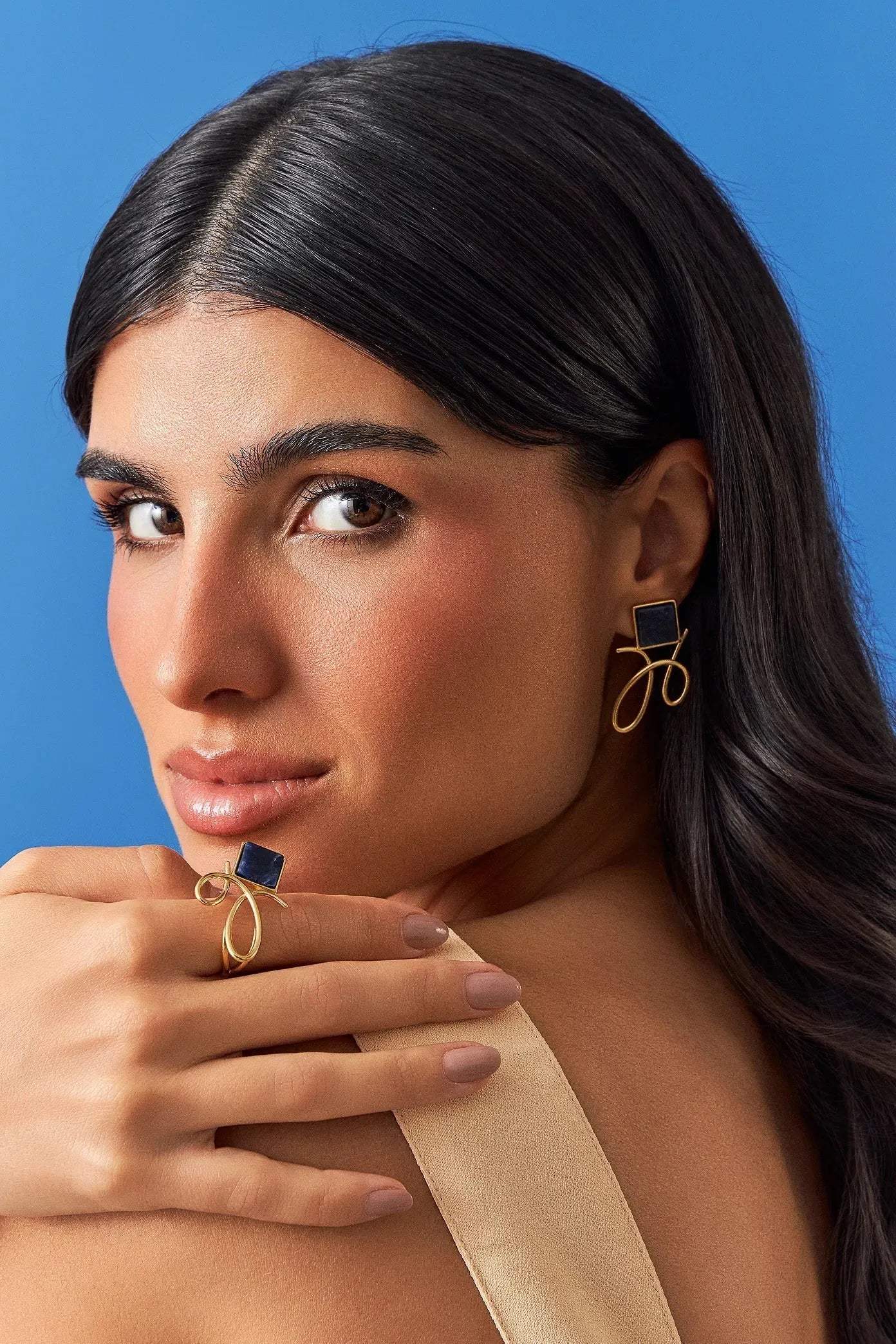 O Brinco Esboço com Sodalita em Banho de Ouro 18K traduz o instante em que o traço encontra a forma. Este brinco pequeno e delicado une a pedra quadrada, que atua como ponto de luz, a um toque sutil de traço. A Sodalita simboliza clareza e intuição. Com sua geometria precisa e o contraste sutil das linhas em metal, esta peça é perfeita para quem busca expressar sofisticação e leveza, elevando o visual com um toque contemporâneo.
