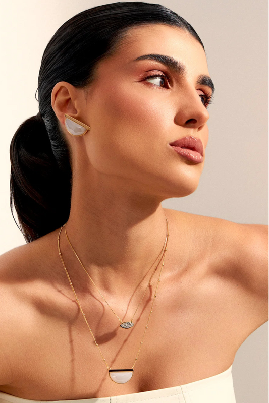 Use o Brinco Escudo para atrair paz interior e bondade. A joia traz a essência da Ágata Branca, uma pedra que fortalece o recolhimento interior, a lealdade e a despreocupação, em um sofisticado Banho de Ouro 18K.