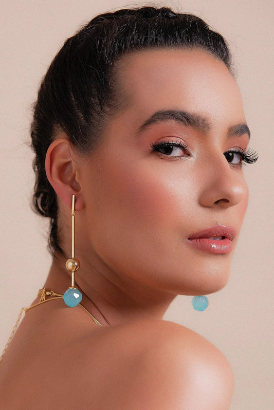 O Brinco Fascínio em Ágata Azul Céu, com Banho de Ouro 18K, possui um visual leve e atemporal. A Ágata Azul Céu, de cor suave, oferece um acabamento delicado e luminoso, realçado pelo brilho do ouro.