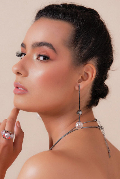 O Brinco Fascínio em Cristal de Rocha, com Banho de Ródio Negro, oferece um brilho intenso e elegante. O Cristal de Rocha Transparente Liso contrasta com o luxuoso acabamento escuro do ródio negro, criando um visual moderno e sofisticado.