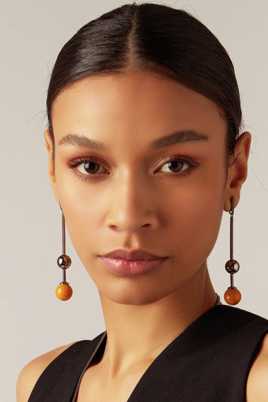 O Brinco Fascínio em Feldspato Amarelo, com Banho de Ródio Negro, possui um visual vibrante e moderno. O Feldspato Amarelo Liso oferece um toque de energia e cor, realçado pelo contraste do acabamento escuro do ródio negro.