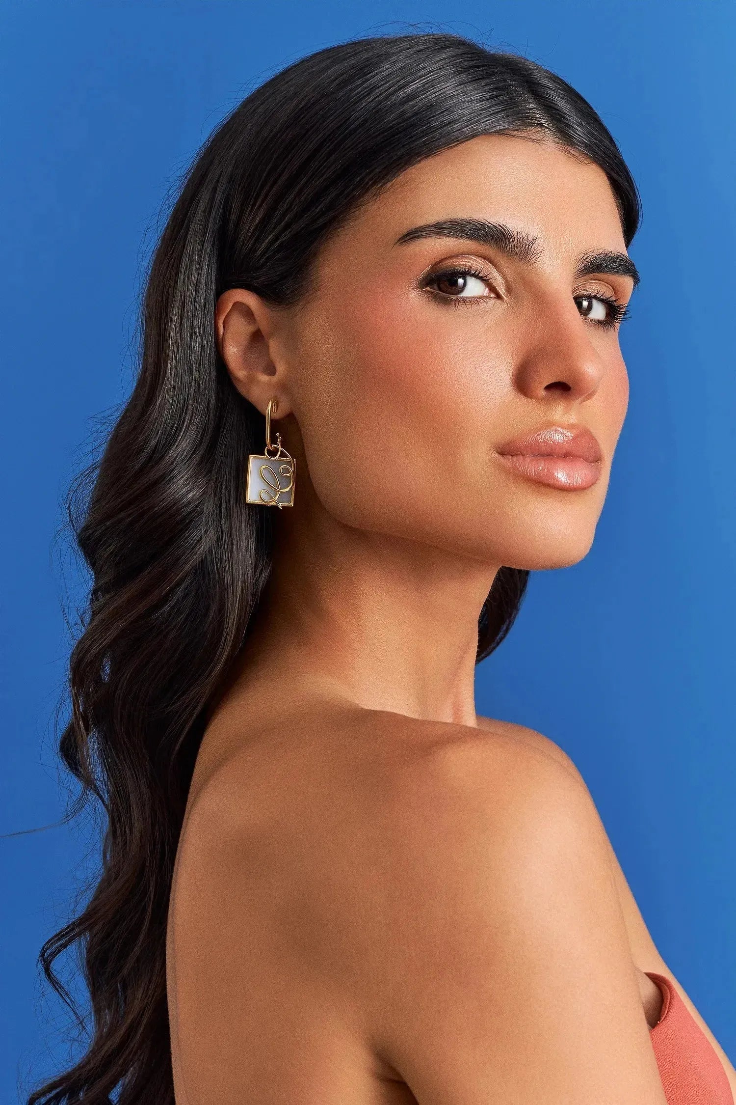 O Brinco Forma com Ágata Branca em Banho de Ouro 18K oferece versatilidade no conceito 2 em 1, com aro liso e pingente geométrico removível. A Ágata Branca simboliza serenidade e paz. Com design contemporâneo de linhas em metal sobre a pedra, esta joia é ideal para expressar clareza e elegância no seu dia a dia.