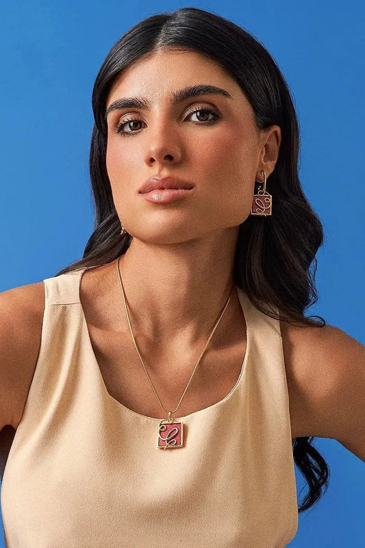 O Brinco Forma com Feldspato Vermelho em Banho de Ouro 18K oferece versatilidade no conceito 2 em 1, com aro liso e pingente geométrico removível. O Feldspato Vermelho simboliza energia e impulso. Com design contemporâneo de linhas em metal sobre a pedra, esta joia é ideal para expressar força de vontade e paixão.