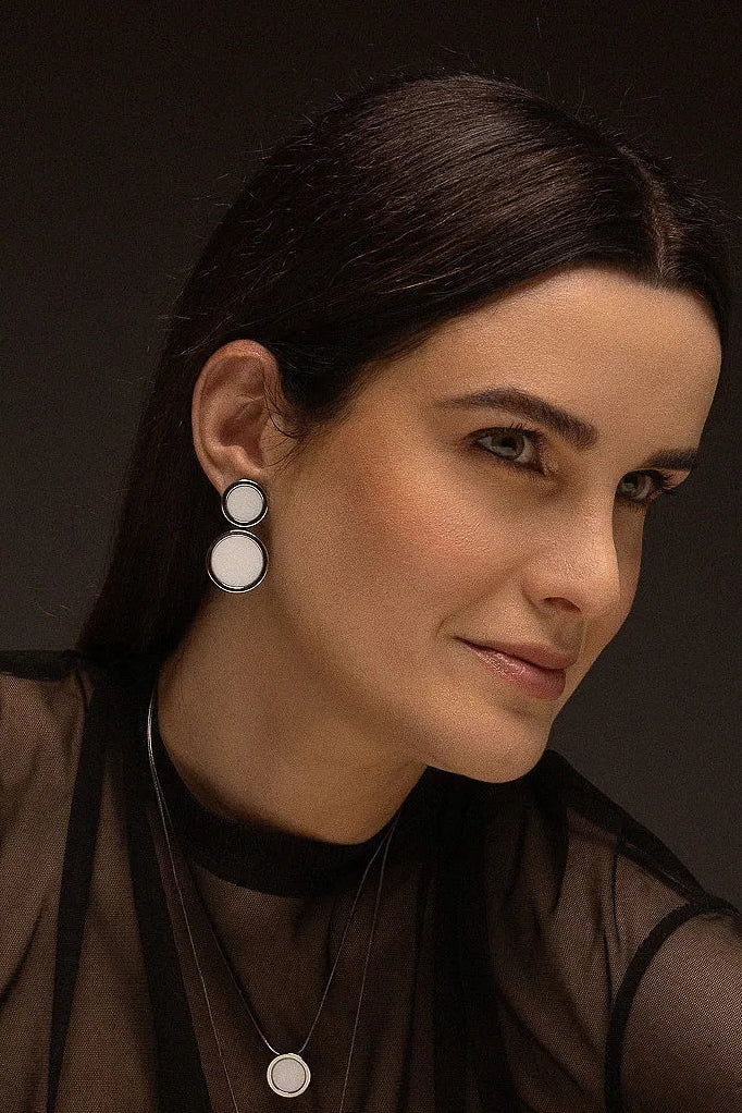 O Brinco Nobre - Porcelana Branca, da Coleção Singular, é uma joia que redefine a sofisticação através do contraste magnético. A Porcelana Branca é um material que simboliza renovação, pureza e clareza mental, ganhando uma estética moderna e imponente quando emoldurada pelo metal escuro. Banhado a Ródio Negro, este brinco de design contínuo e marcante é a escolha ideal para a mulher que busca uma peça atemporal com um toque de ousadia e elegância contemporânea.