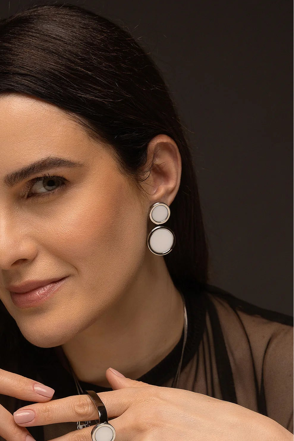 O Brinco Nobre - Porcelana Branca, da Coleção Singular, é uma joia que redefine a sofisticação através do contraste magnético. A Porcelana Branca é um material que simboliza renovação, pureza e clareza mental, ganhando uma estética moderna e imponente quando emoldurada pelo metal escuro. Banhado a Ródio Negro, este brinco de design contínuo e marcante é a escolha ideal para a mulher que busca uma peça atemporal com um toque de ousadia e elegância contemporânea.