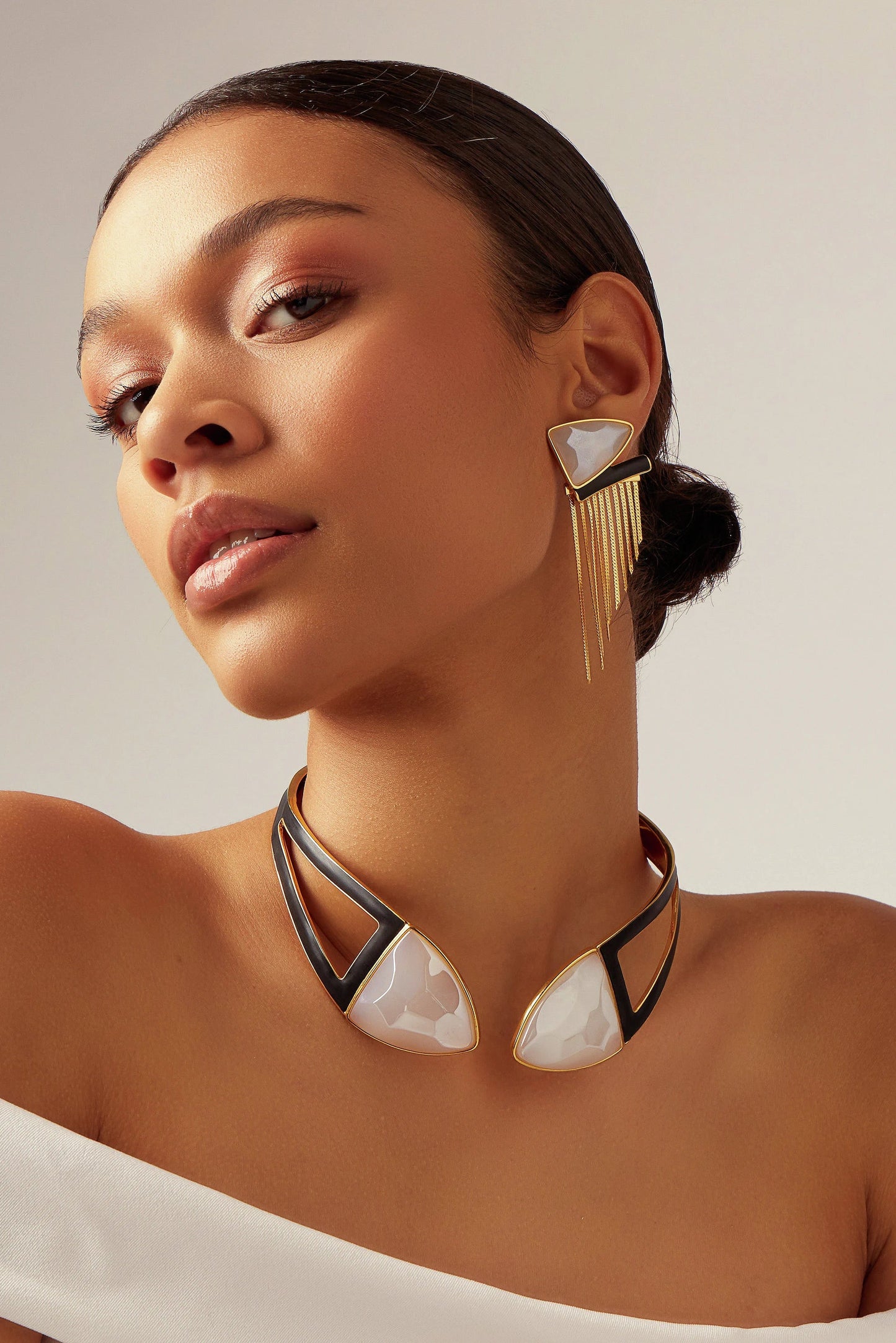 A Choker Makeda é uma peça imponente da Coleção Atemporal. O design geométrico e multifacetado é enriquecido com Ágata Branca e detalhes em Esmalte Preto, tudo em um luxuoso Banho de Ouro 18K.