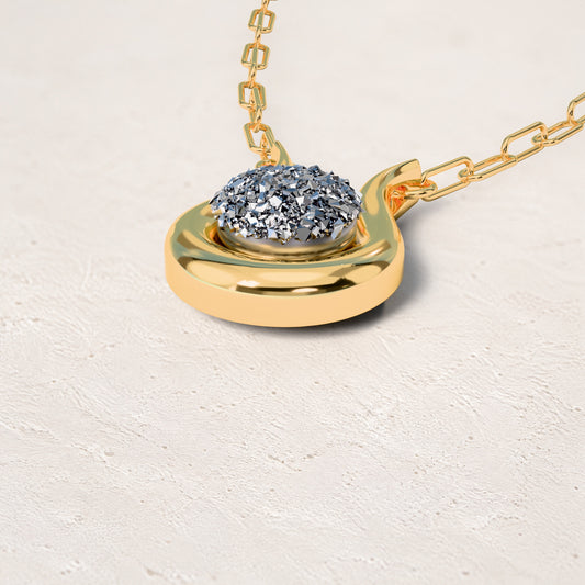 Colar Órbita - Drusa Metalizada: sobre pedestal de gesso em forma de nuvem, fundo de céu azul-claro. Semijoia banhada a ouro 18k, coleção Supernova, Aimer Joias