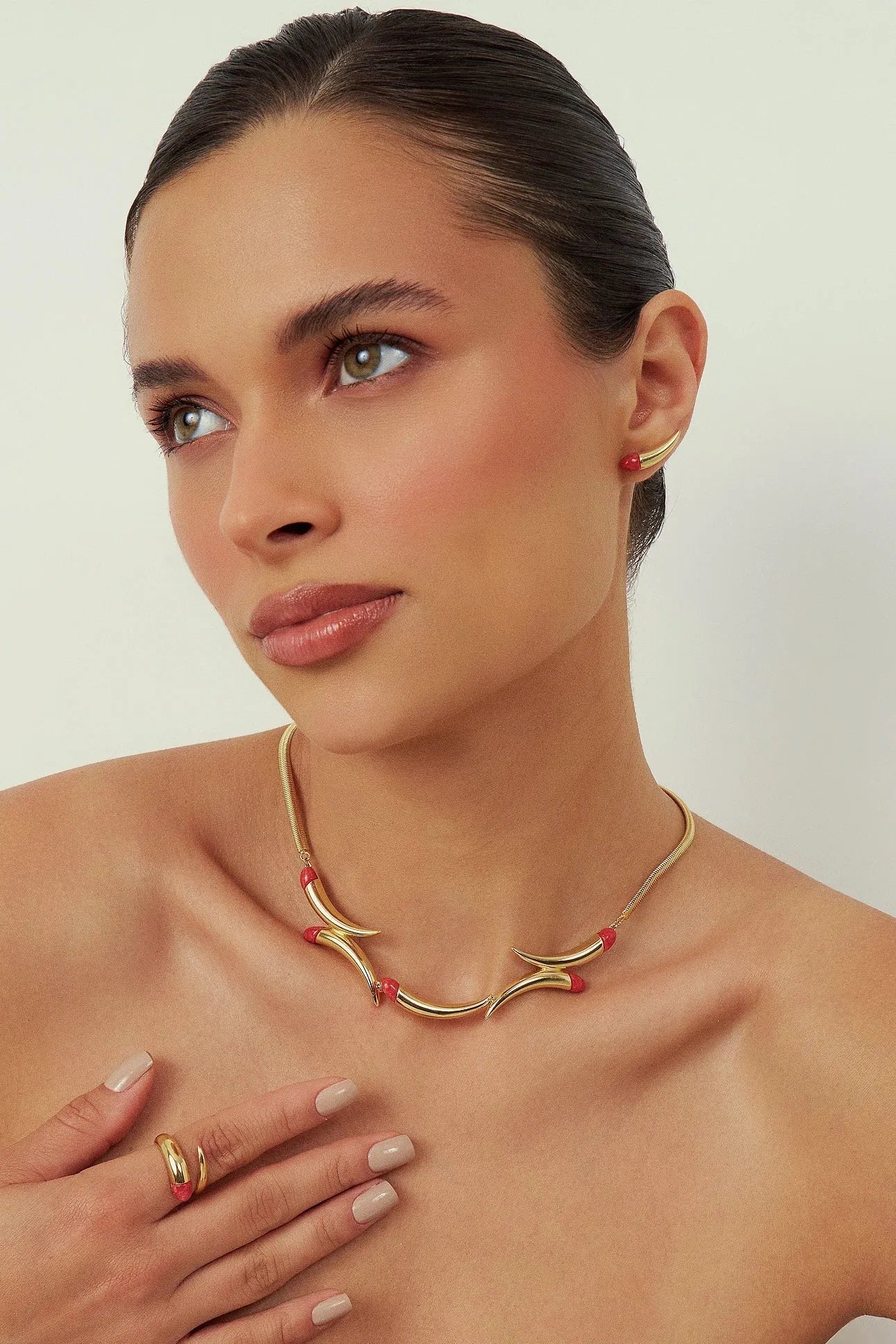 O Colar Caminhos com Feldspato Vermelho em Banho de Ouro 18K é uma joia de luxo que confere energia e paixão, unindo a força da pedra ao brilho imponente do ouro.