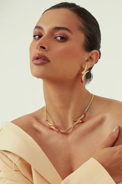 O Colar Caminhos com Feldspato Vermelho em Banho de Ouro 18K é uma joia de luxo que confere energia e paixão, unindo a força da pedra ao brilho imponente do ouro.