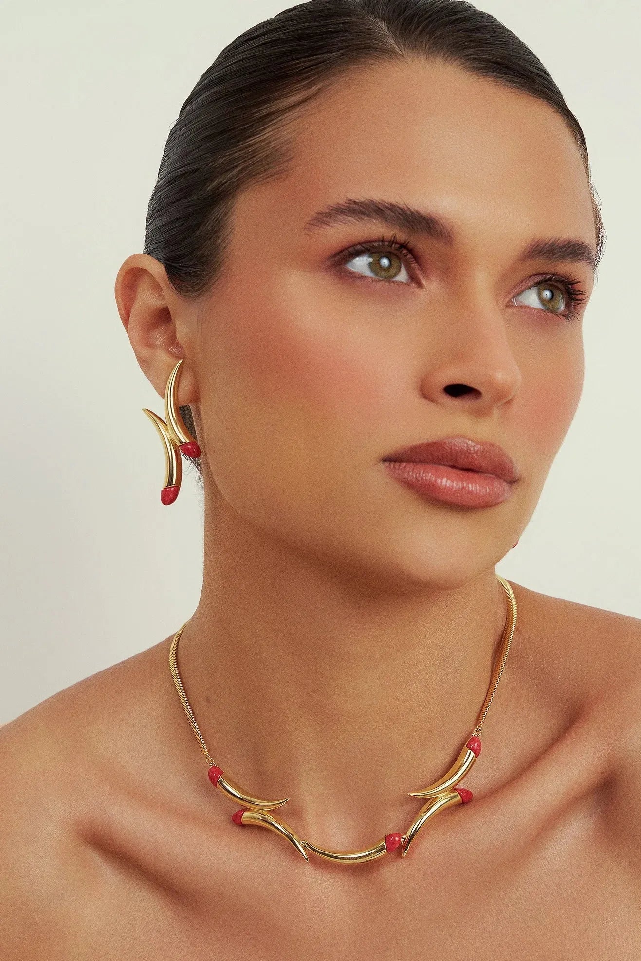 O Colar Caminhos com Feldspato Vermelho em Banho de Ouro 18K é uma joia de luxo que confere energia e paixão, unindo a força da pedra ao brilho imponente do ouro.