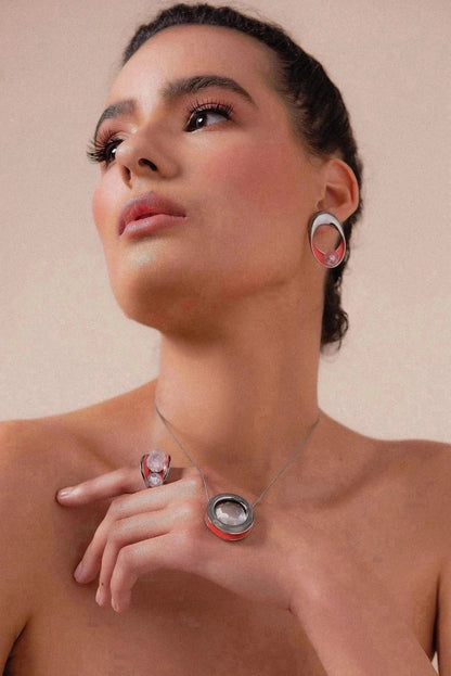 O Colar Energia em Esmaltado Laranja e Cristal de Rocha, com Banho de Ródio Negro, cria um visual de alto contraste e contemporâneo. A transparência do cristal harmoniza-se com o esmalte laranja vibrante, realçado pelo acabamento escuro do ródio negro.