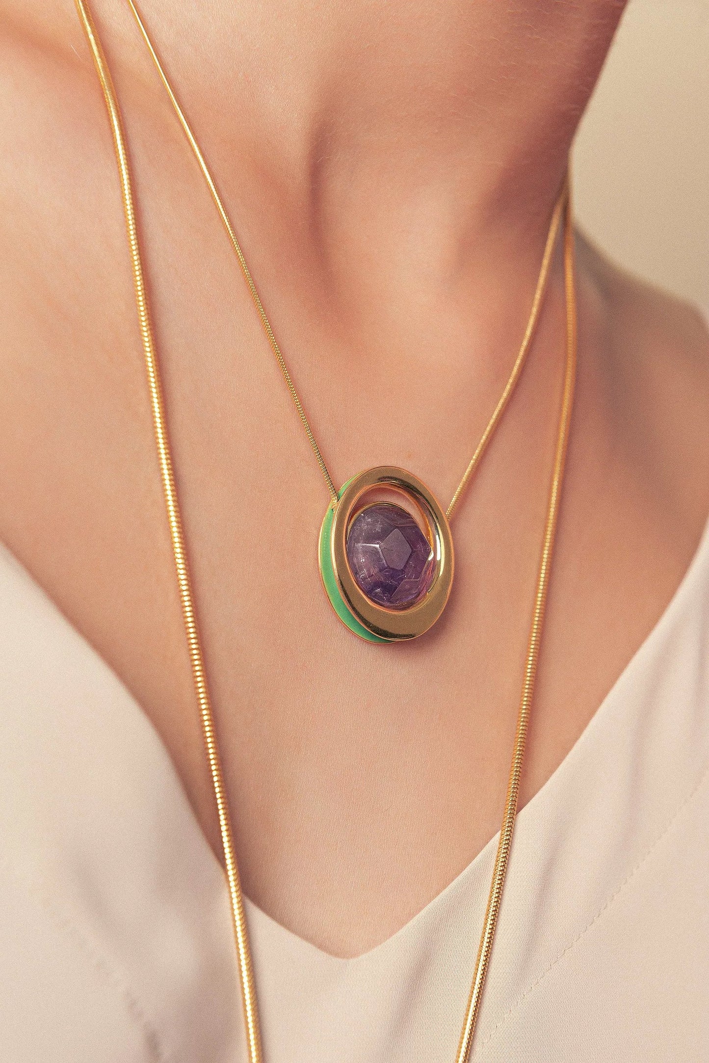 O Colar Energia em Esmaltado Verde Oliva e Ametista Multifacetada, com Banho de Ouro 18K, cria um visual de impacto. A lapidação facetada da Ametista realça seu tom roxo, em harmonia com o esmalte verde oliva e o brilho luxuoso do ouro 18K.