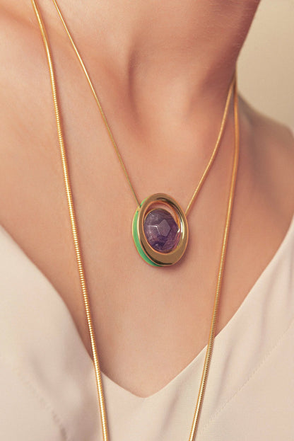 O Colar Energia em Esmaltado Verde Oliva e Ametista Multifacetada, com Banho de Ouro 18K, cria um visual de impacto. A lapidação facetada da Ametista realça seu tom roxo, em harmonia com o esmalte verde oliva e o brilho luxuoso do ouro 18K.