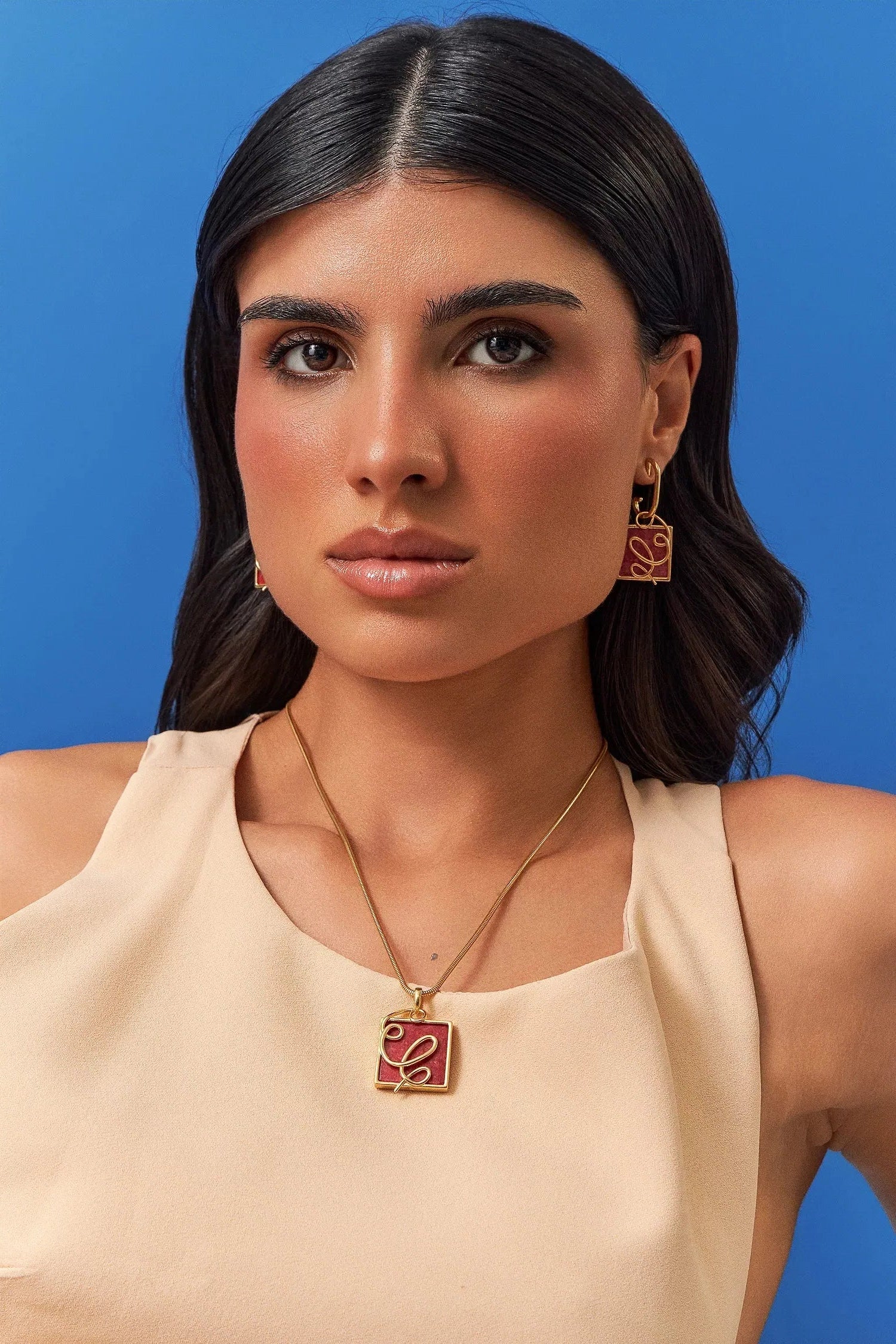 O Colar Forma com Feldspato Vermelho em Banho de Ouro 18K traduz o ponto em que o traço ganha direção. A pedra quadrada de Feldspato Vermelho, que simboliza vitalidade e paixão, recebe a aplicação de linhas em metal que se cruzam, criando uma linguagem super contemporânea. Com sua corrente robusta, é uma peça moderna e sofisticada, ideal para quem busca energia e força de vontade.