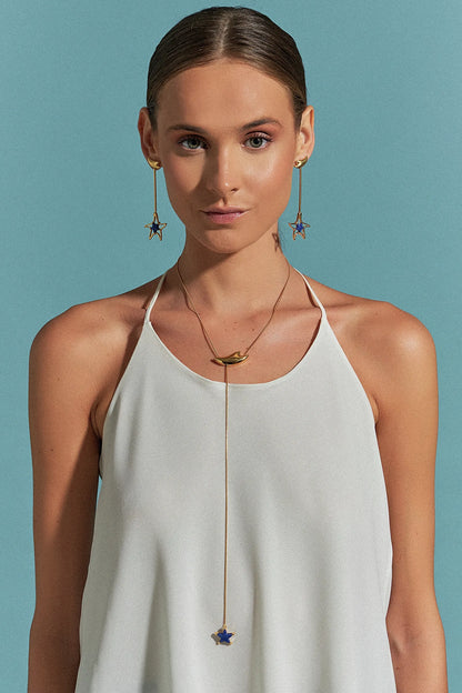 O Colar Serena é uma gravatinha graciosa adornada com uma estrela na ponta e um detalhe de onda que se movimenta. Seu design ajustável reflete a fluidez e a liberdade do mar, perfeito para compor decotes.

Use o Colar Serena com Quartzo Azul Anil em Banho de Ouro 18K para promover paz e harmonia. O brilho do ouro e o tom sereno do quartzo trazem leveza e sofisticação ao seu visual.